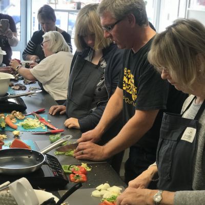 Learning hands on cookery skills, cutting peppers and potatoes